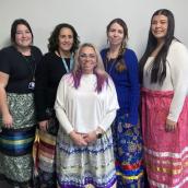 A group of women stand smiling at the camera.