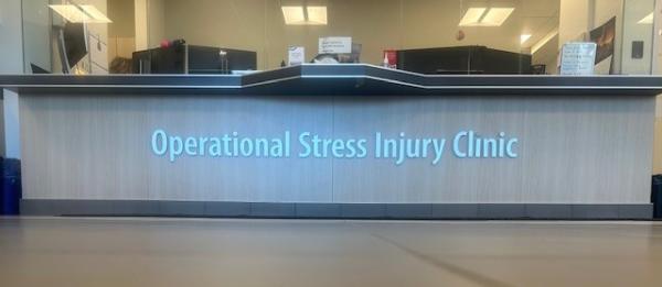 A desk with the words Operational Stress Injury Clinic lit up in blue.