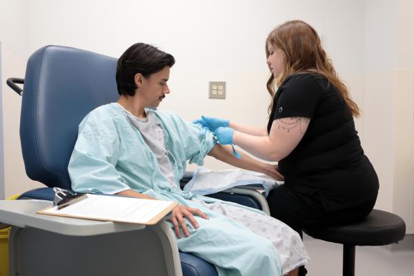 Patient being prepped for scan by MRI Technologist