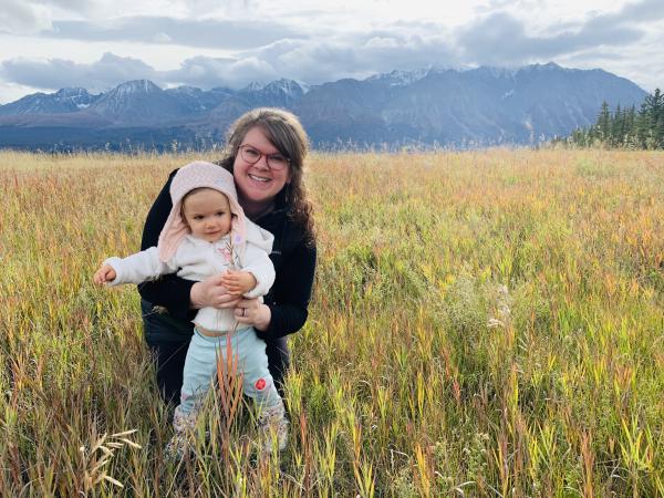 Dr. Alison Freeman, Family Physician in Liverpool, Nova Scotia. She is smiling and standing outdoors with a child, both looking at the camera.